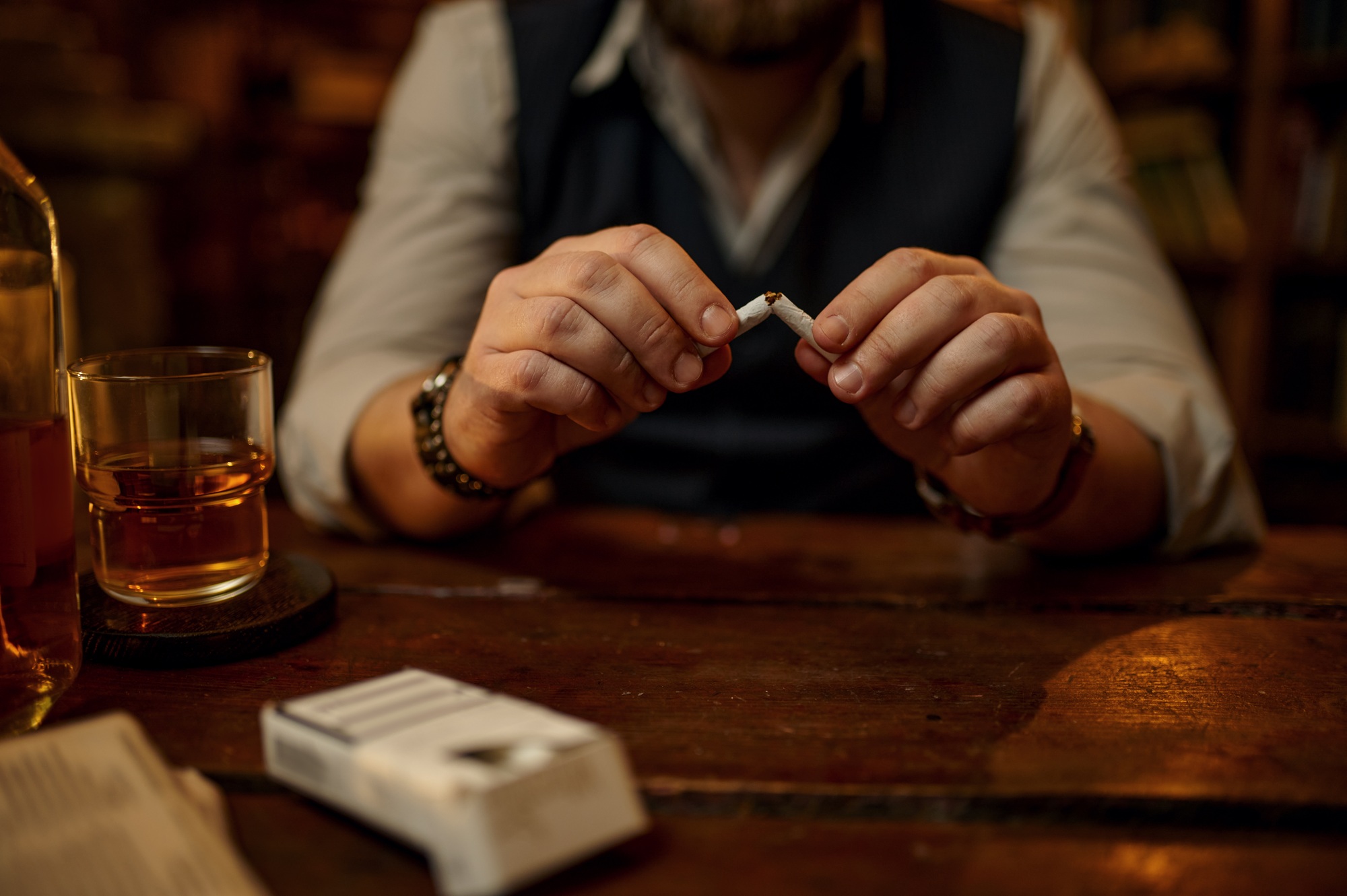 Man breaks a cigarette, bad habit and addiction